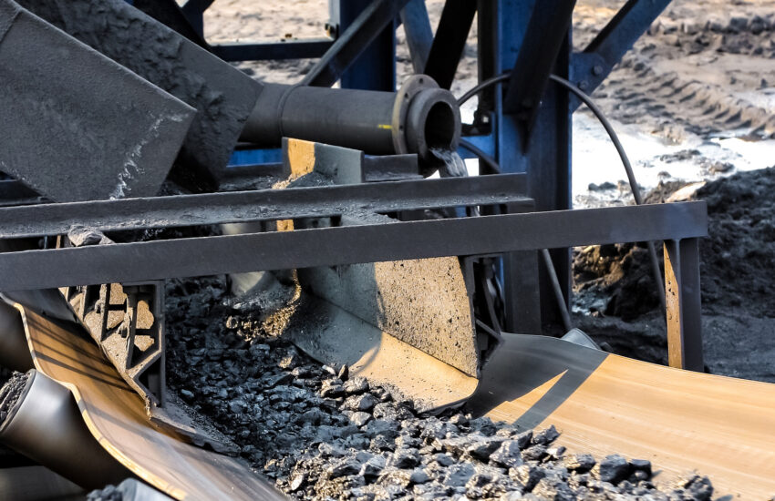 Conveyor belt moves coal or ore at industrial site.