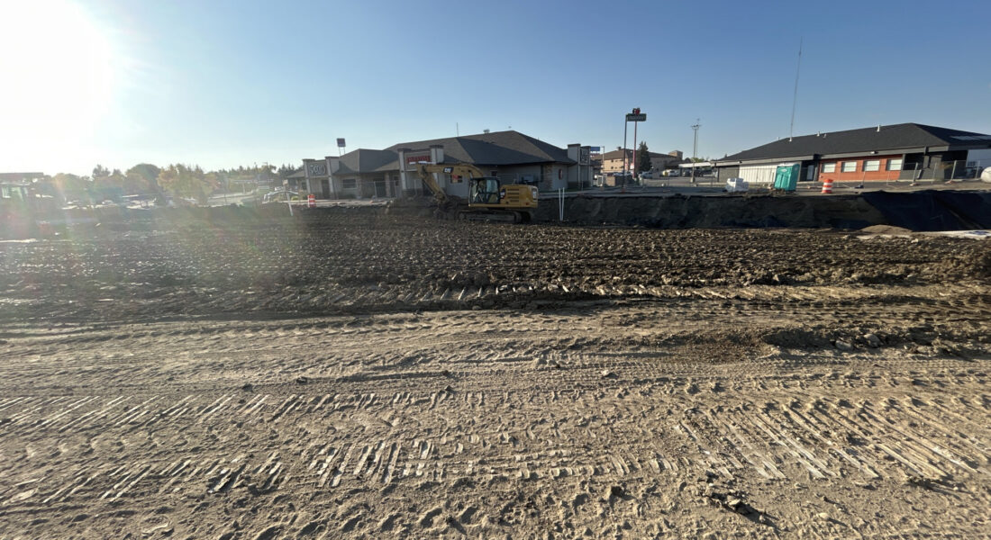 Yellow excavator on dirt at a construction site in Minot.