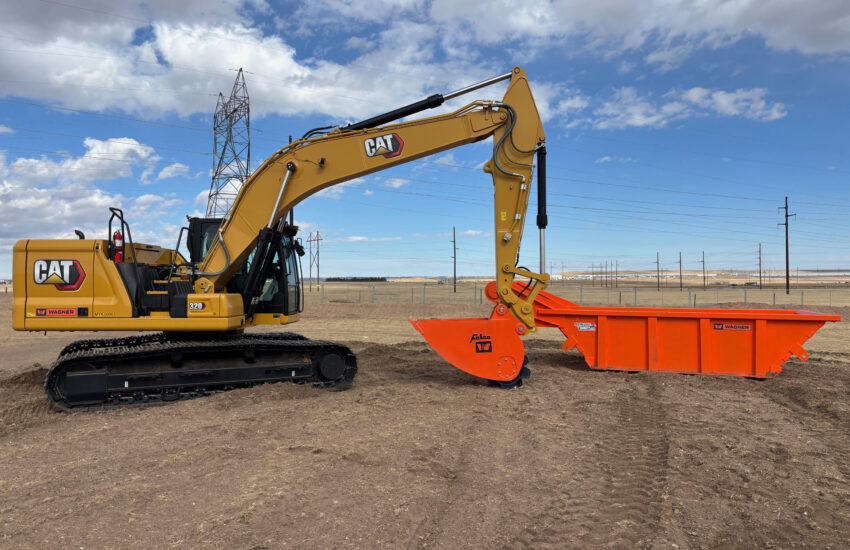 Yellow Caterpillar excavator with orange attachment on dirt, power lines behind.